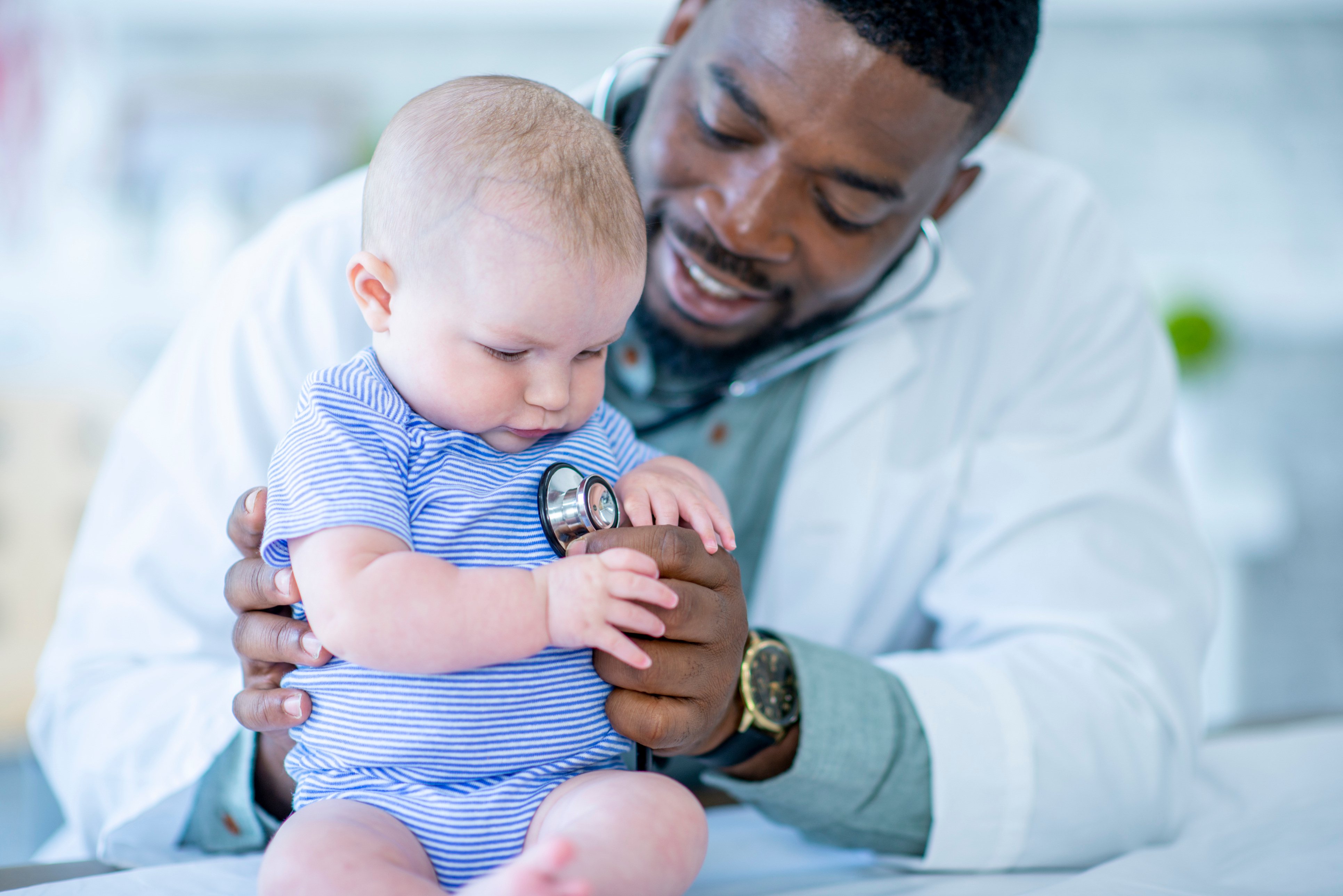 Doctor places stethoscope on baby's chest