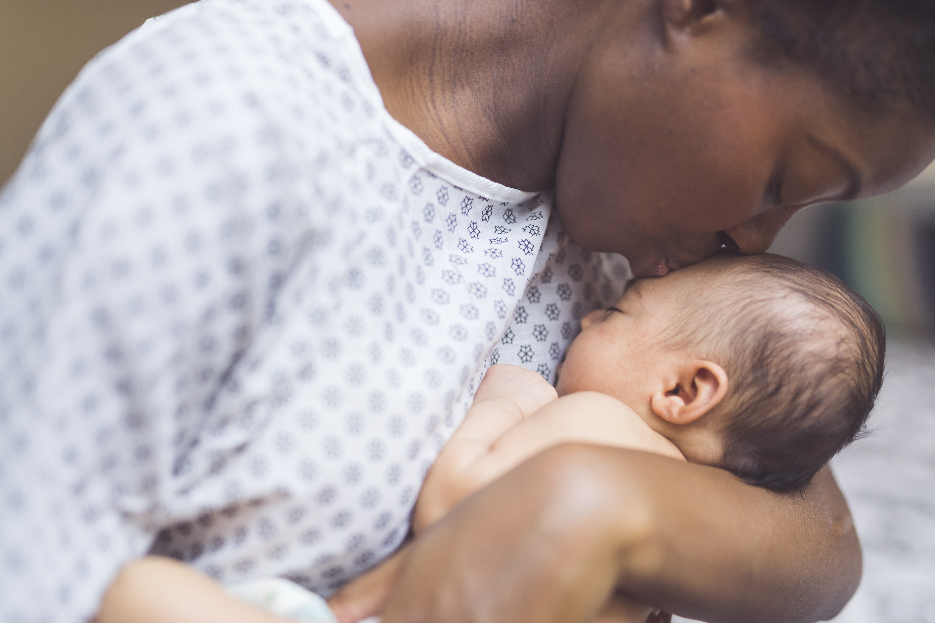 Newborn baby held by mother in a hospital gown